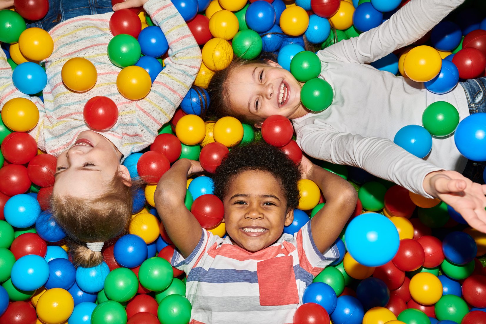 Three Happy Kids Playing in Ballpit